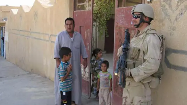 Иракская семья говорит с американским солдатом в Таль-Афаре, Ирак, сентябрь 2005 года