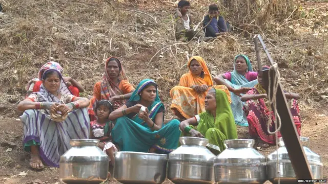 पाणी येण्याची वाट बघताना महिला.