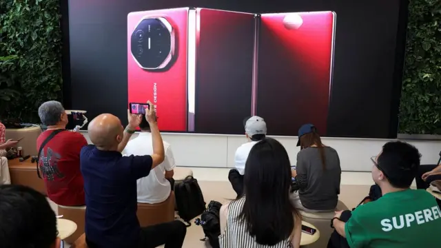 People watch the launch event of Huawei's new Mate XT, a three-way foldable smartphone, live-streamed at a Huawei flagship store in Beijing, China September 10, 2024