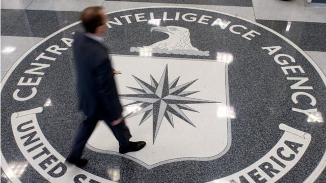 Un hombre camina sobre el logo de la CIA.