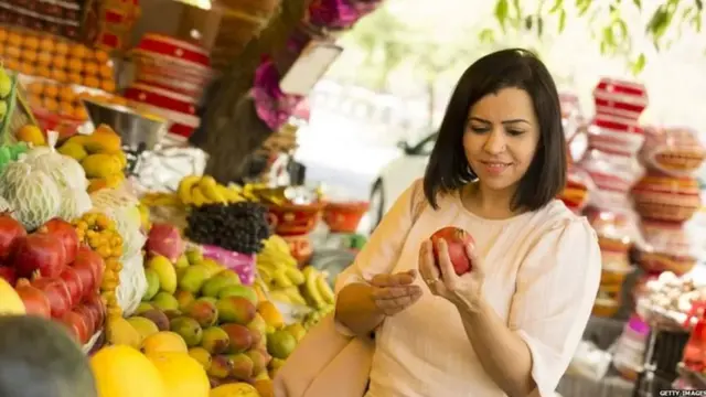 ਫਲ ਖਰੀਦ ਰਹੀ ਔਰਤ