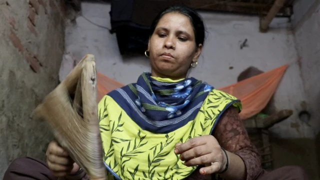 रेशम का धागा निकालती एक महिला