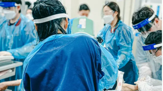 '사진 찍는 간호사' 이강용 씨가 가장 좋아하는 사진. 방역복을 입고 땀으로 흠뻑 젖은 의료진들이 한 명의 환자를 살리기 위해 모여있다. 그는 "다 다른 타이틀과 위치가 다른 의료진들이 환자 한 명을 살리기 위해 다 달려들어 각자의 일을 하는 모습을 보면 희열이 느껴진다"고 했다