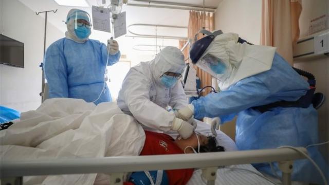 Mulher é atendida por médicos em hospital de Wuhan