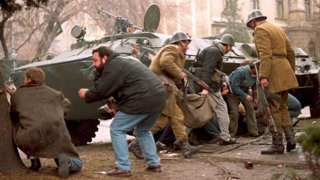 Militares e civis romenos se escondem de atiradores no centro de Bucareste, em 24 de dezembro de 1989