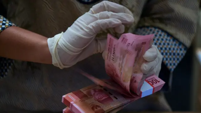 Teller menghitung uang di Bank BNI, Jakarta, Kamis (21/04)