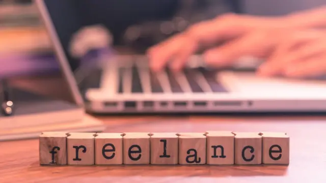 Letrero de freelance frente a una computadora.