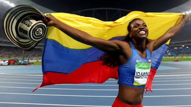 Caterine Ibargüen festeja con la bandera de Colombia