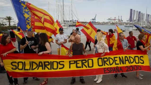 اسپانیایی‌های مخالف ورود مهاجران آفریقا با تجمع در بندر والنسیا روی پارچه نوشته‌اند که احساس همدردی دارند اما همه چیز باید قانون داشته باشد