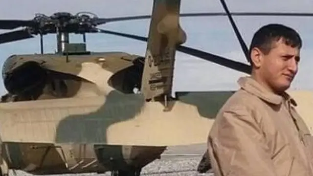 Momand standing n front of his helicopter