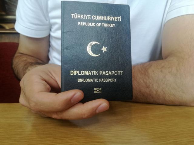 Офицер показывает дипломатический паспорт
