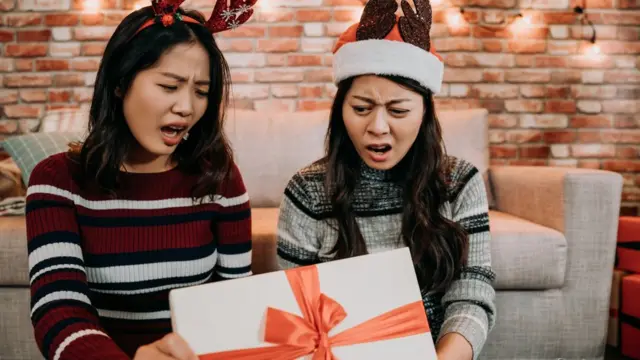 Dos chicas decepcionadas ante el contenido de una caja.