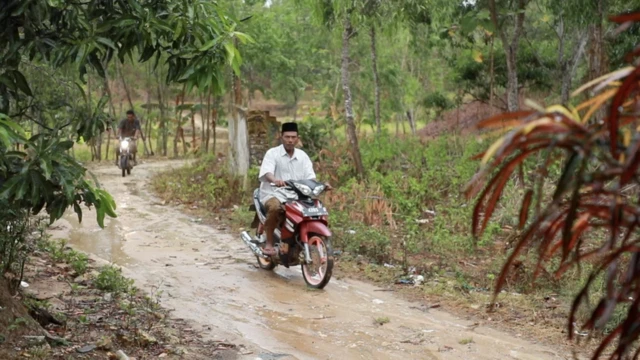 Seorang warga melintas menggunakan sepeda motor di bekas rumah dan pesantren Tajul Muluk di Karang Gayam, Madura.