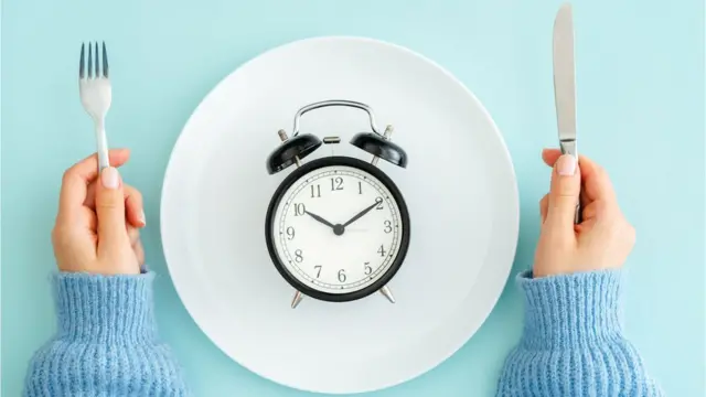 Un reloj sobre un plato de comida vacío.