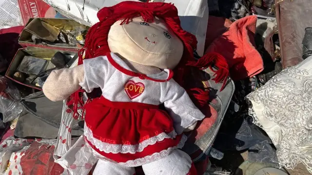 لعبة طفل وسط أنقاض مبنى سكني منهار