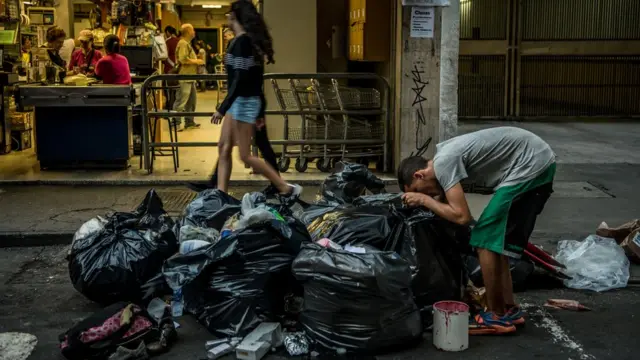 Un joven rebusca entre la comida