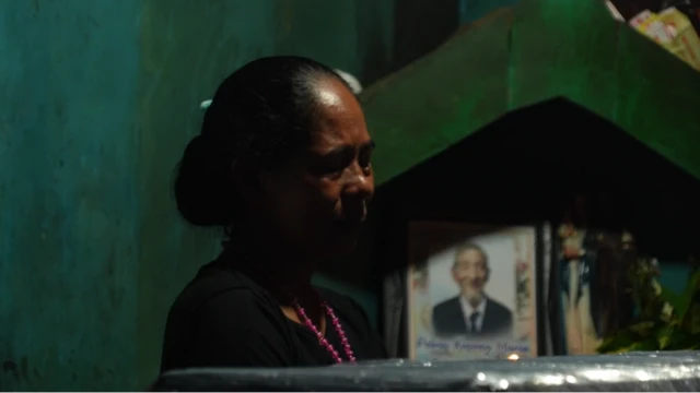 Seorang perempuan menangis di depan peti jenazah Yasinta.