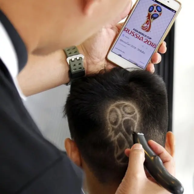 ช่างผมชาวไทยกำลังบรรจงลูกค้าเพื่อให้ตราสัญญลักษณ์ฟุตบอลโลก 2018