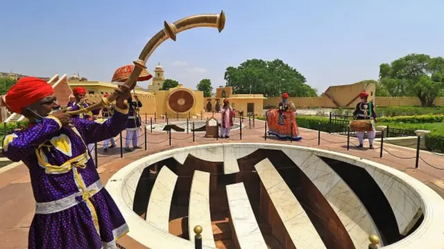 Фольклорный музыкант возвещает торжественное открытие дворца-музея в городе Джайпур в Индии