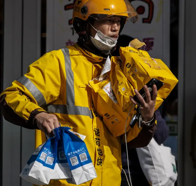 A delivery man carries medical necessities in front of a pharmacy in Shanghai, China, 29 March 2022. On 29 March 2022,