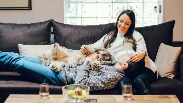 Casal no sofá com cachorro