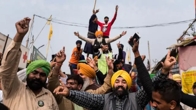 कृषी कायदे रद्द करण्यात आल्यानंतर आनंद साजरा करणारे दिल्लीच्या सीमेवरील शेतकरी