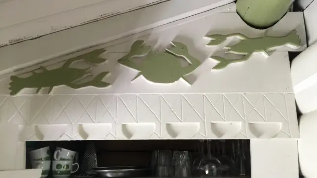 Grabados de cangrejo y moluscos sobre la pared.