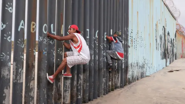 Des migrants tentent d'escalader le mur