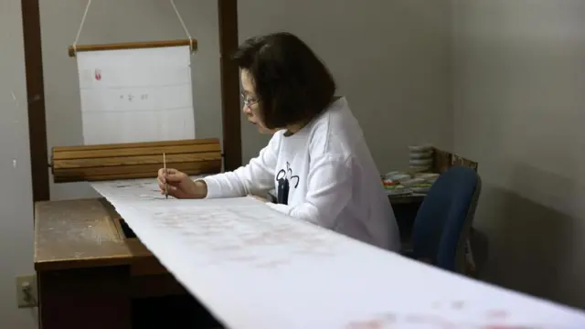 Seorang pengrajin perempuan melakukan shokunin.