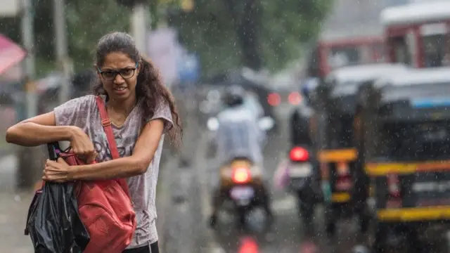 વરસાદમાં જતી યુવતીની તસવીર