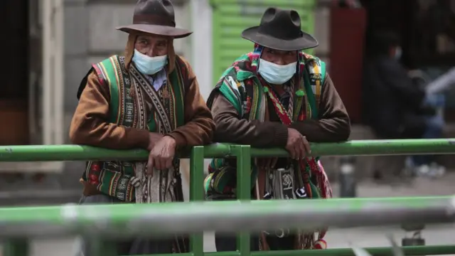 Dois bolivianos andam com máscaracbet gg appproteção contra a covid-19 na rua