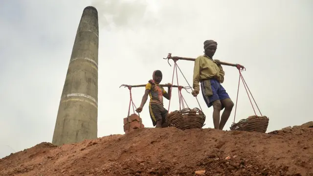 ఇటుక రాళ్ల కావడులతో ఇద్దరు కార్మికులు