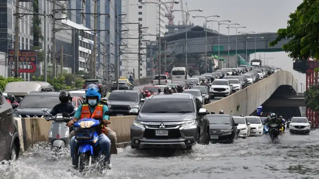 สภาพน้ำท่วมบนถนนถนนรัชดาภิเษกบริเวณแยกรัชดา-ลาดพร้าว เมื่อช่วงเช้าวันที่ 18 พ.ค. ยังคงมีน้ำท่วมสูง ทำให้รถยนต์และรถมอเตอร์ไซค์ต้องวิ่งลุยน้ำ ขณะที่การจราจรบริเวณดังกล่าวติดขัดเป็นอย่างมาก