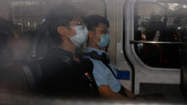 钟翰林（中）由警车押送至香港西九龙裁判法院出庭（29/10/2020）