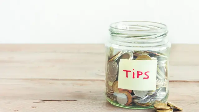 Tip jar filled with coins