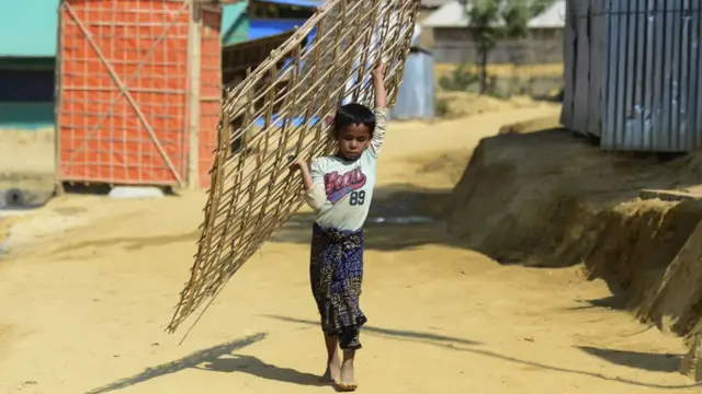 अपने घर के काम करते हुआ एक रोहिंग्या बच्चा