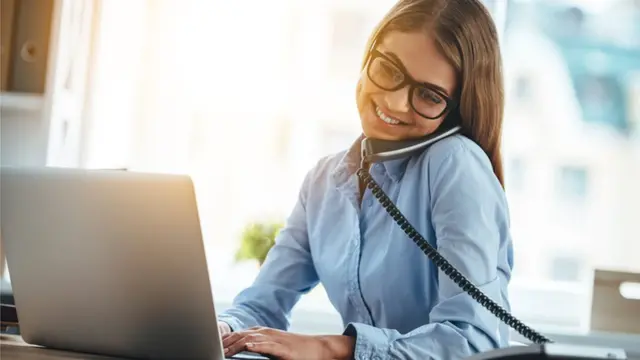 موظفة تعمل وتتحدث في الهاتف