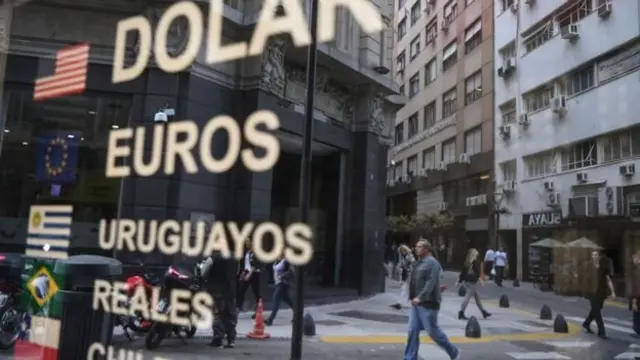 Placa mostra símbolos de dólares, euros e pesos