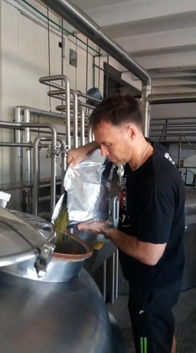 ไมเคิลกำลังใส่ส่วนผสมของฮอปส์ ซึ่งเป็นวัตถุดิบชนิดหนึ่งในการทำเบียร์