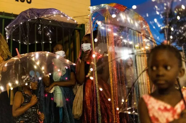 Les gens portent des costumes lumineux et tiennent des lumières.