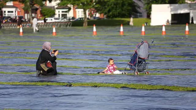 Haweenay sawir ka qaadaysa ilmo yar