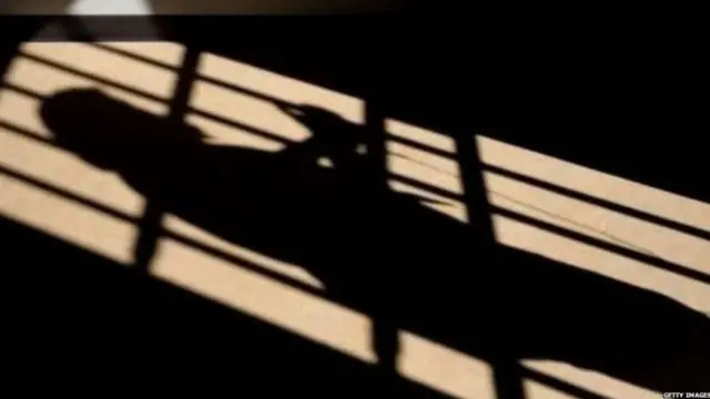 ਸਲਾਖਾਂ ਮਗਰ ਖੜ੍ਹੇ ਵਿਅਕਤੀ ਦਾ ਪਰਛਾਵਾਂ