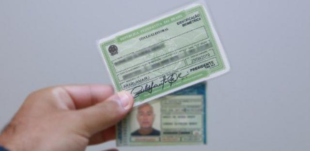 Uma mão segura um titulopokerstars casino brasileleitor