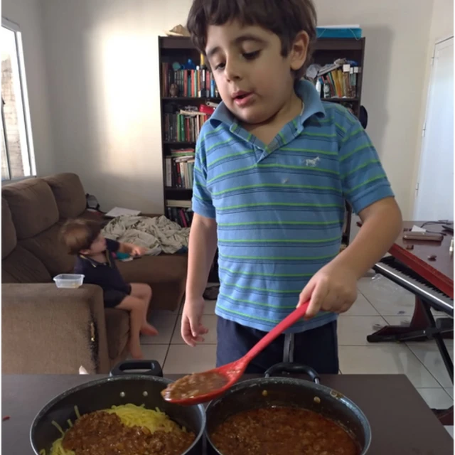 Joaquim misturando molho com massa de macarrão