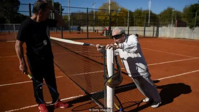 अर्मेनिया में जन्मे 100 साल के आर्टिन एलमायन टेनिस खेलने से पहले स्ट्रेचिंग करते हुए