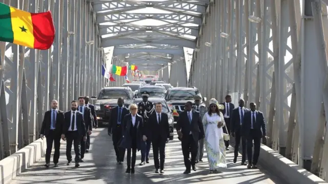Les couples présidentiels, en marche, sur le pont Faidherbe.
