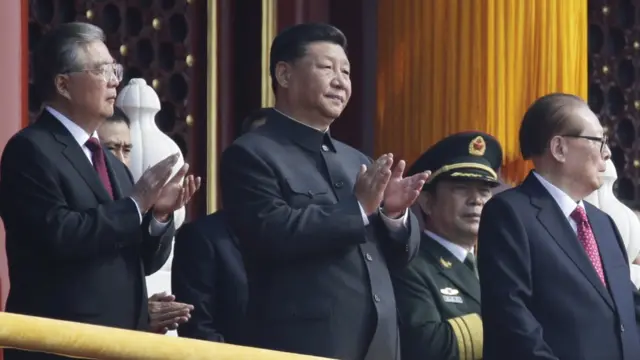 Chinese President Xi Jinping applauses next to former president Jiang Zemin