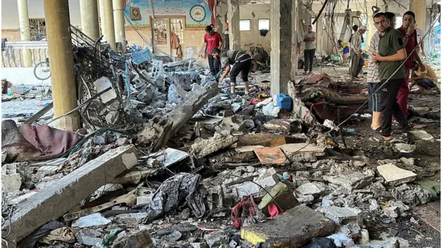 Muškarci pretražuju ruševine škole u Gazi