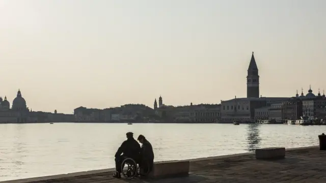 شخصان يجلسان أمام بحيرة