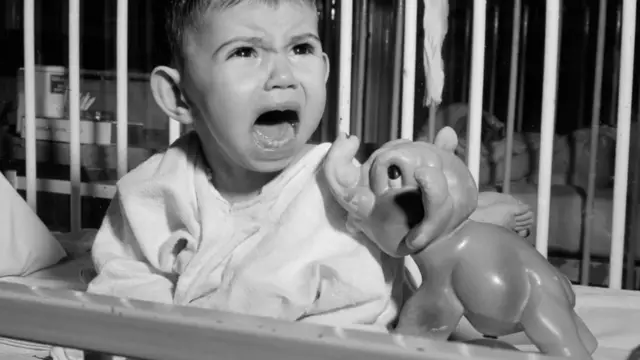 Niño llora en su cuna.